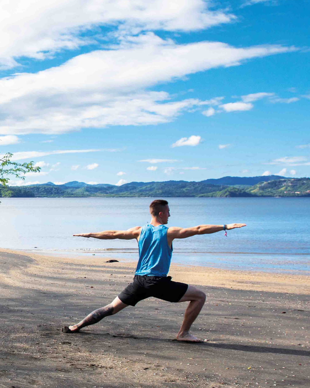 a man doing yoga on a beach