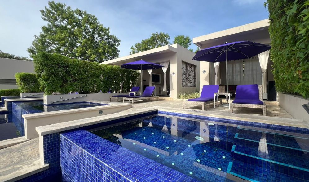 a pool with purple chairs and umbrellas