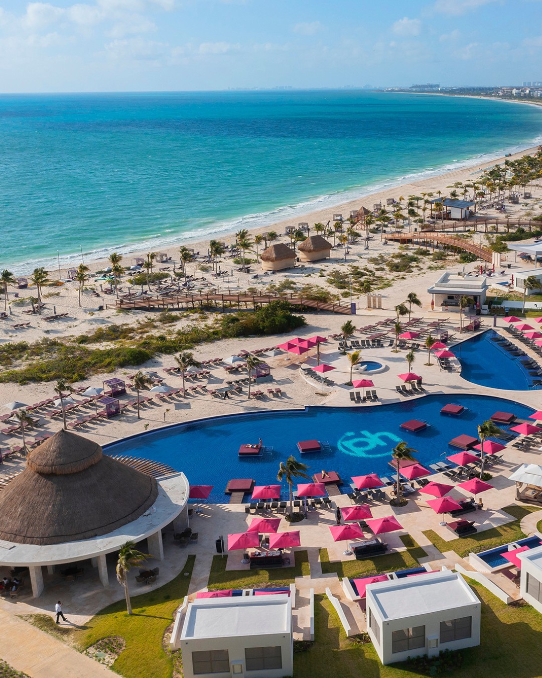 a beach with a swimming pool and a large body of water