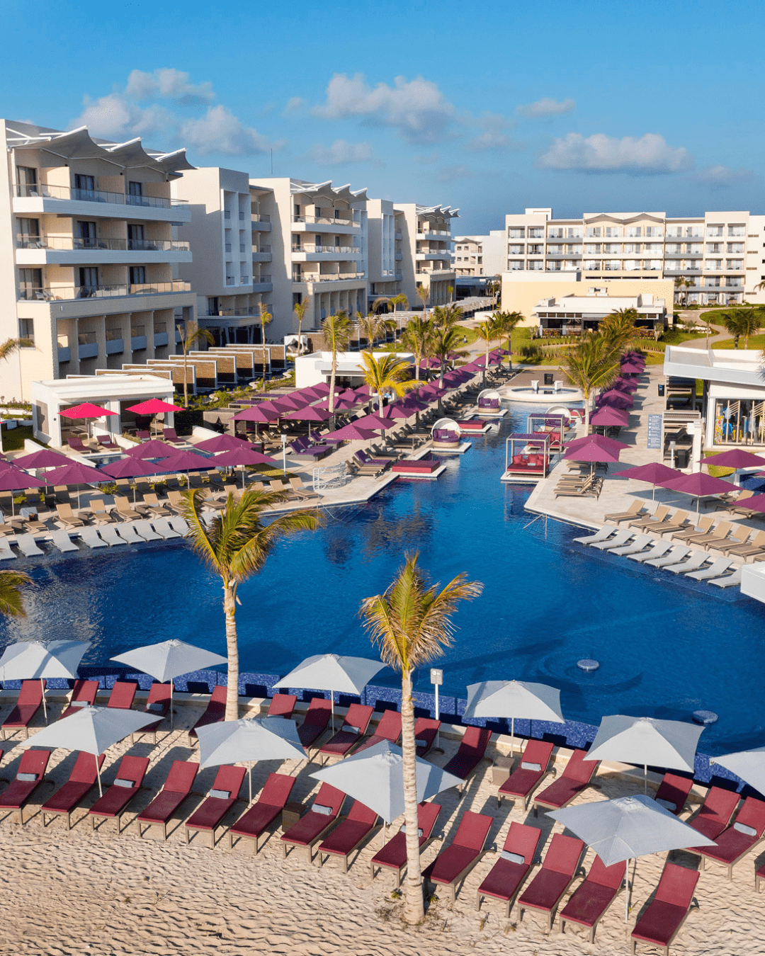 a pool with umbrellas and chairs in a resort