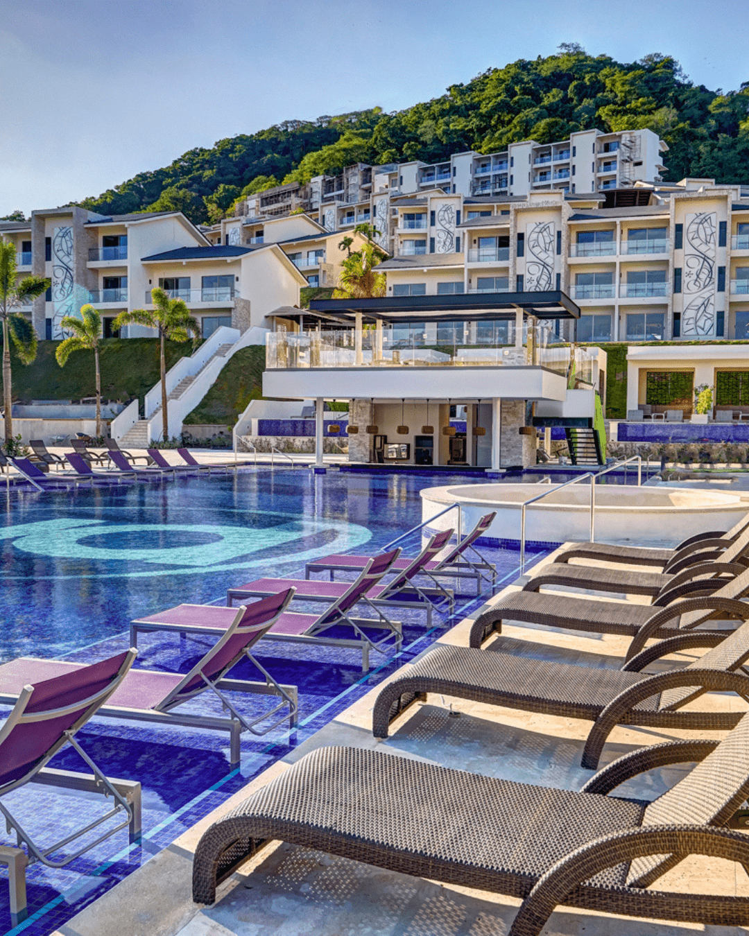 a pool with chairs and a building in the background