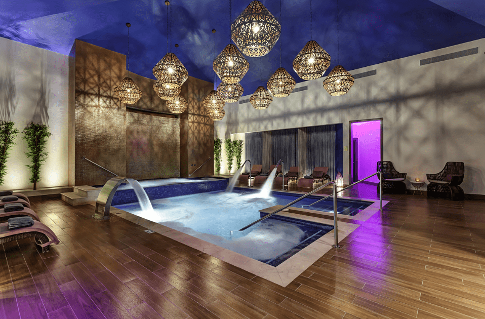 a indoor pool with water jets and chandeliers