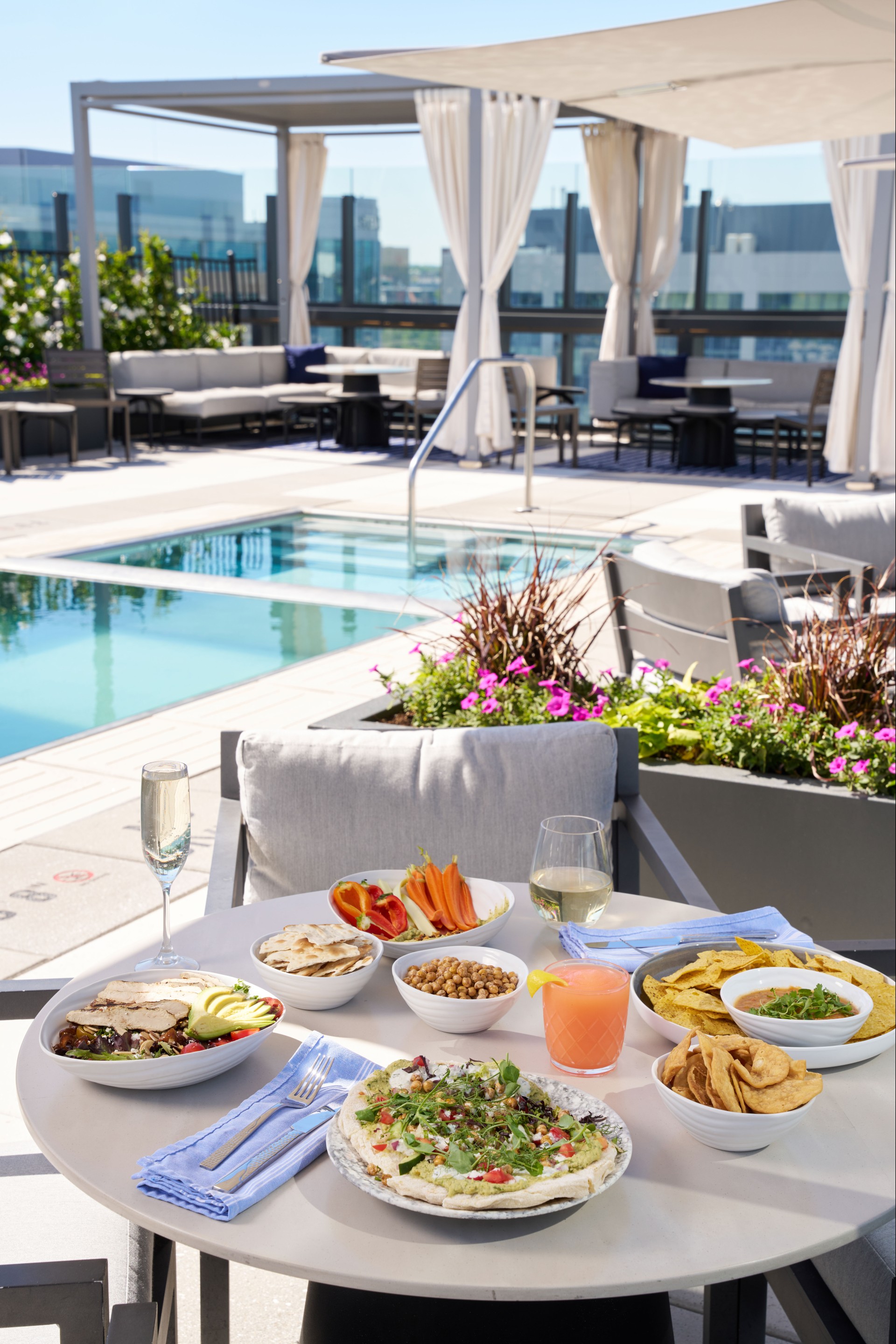 a table with food and drinks on it by a pool