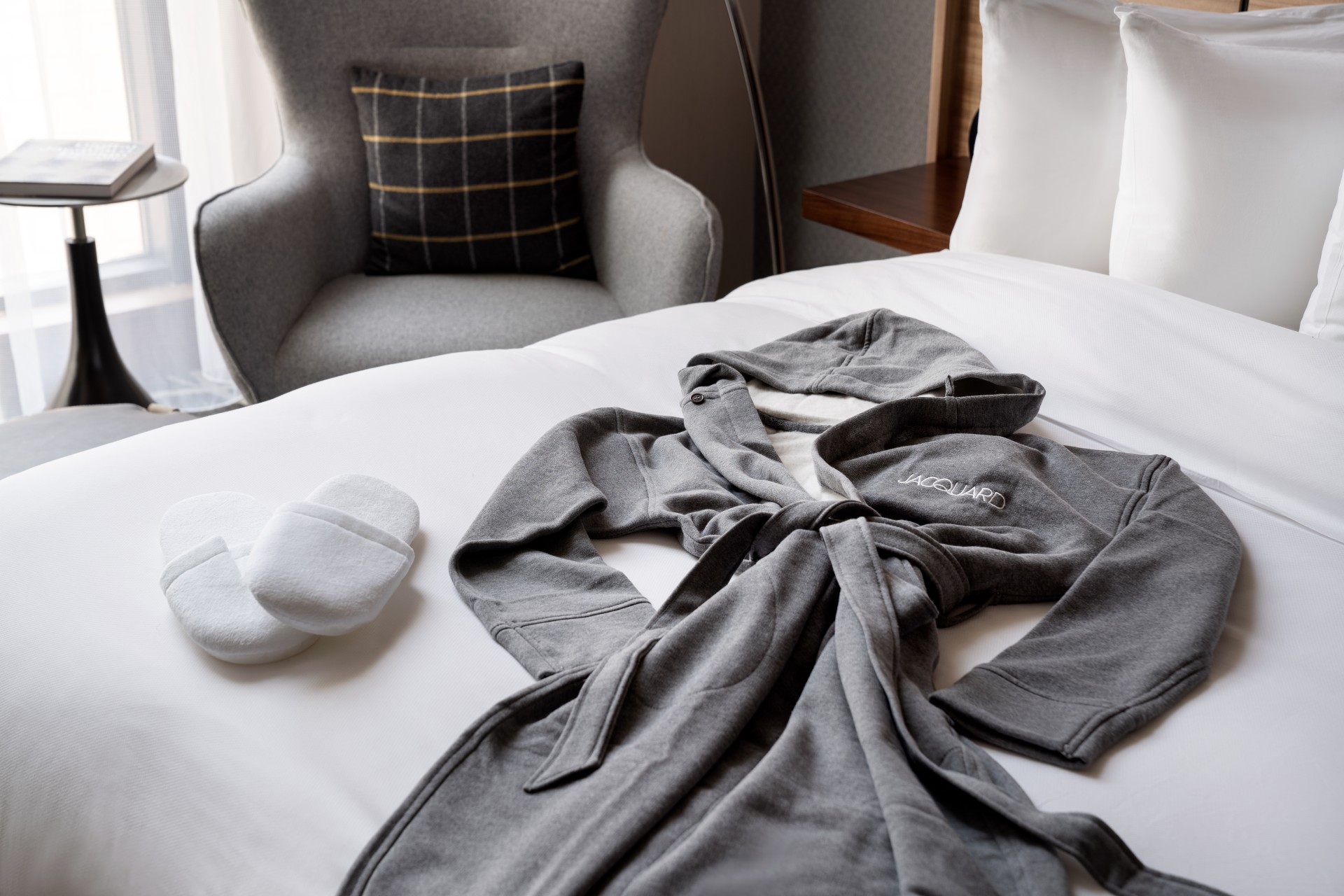 a grey robe and slippers on a bed main