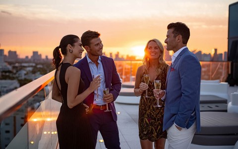a group of people standing on a rooftop with drinks