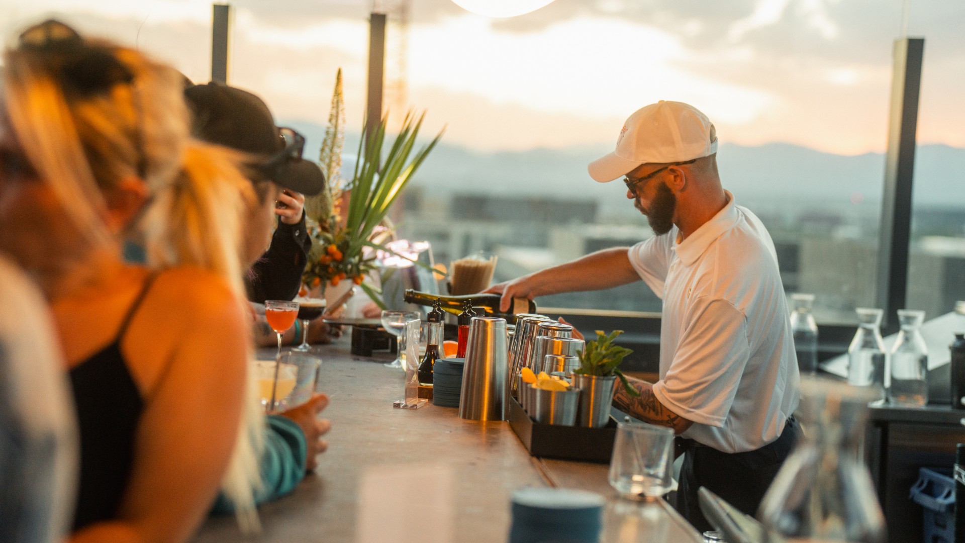 a man pouring wine at the Kisbee on the Roof bar