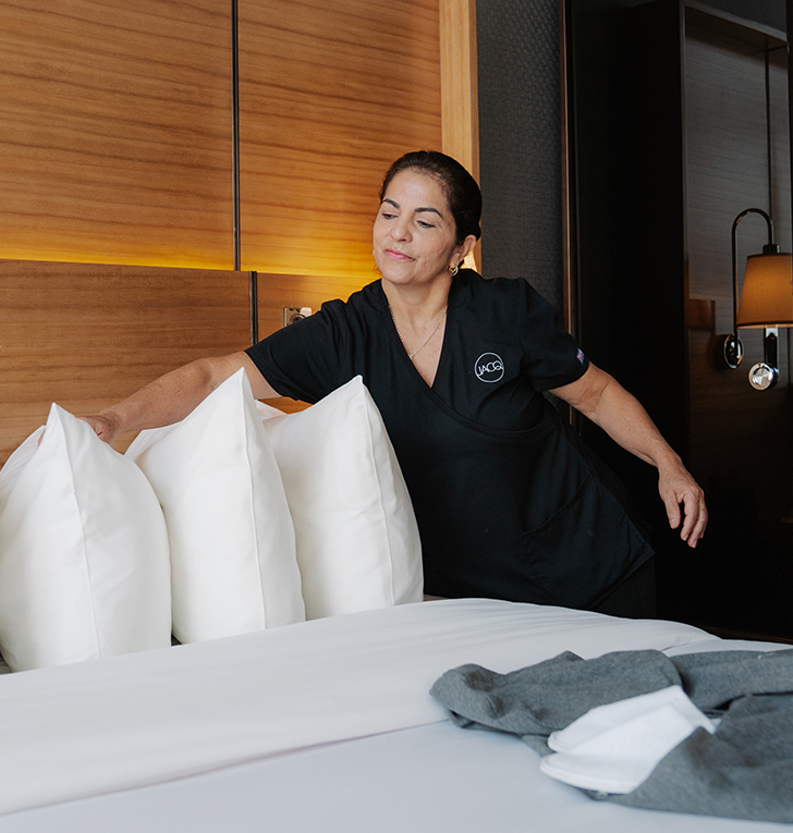 a woman standing next to a bed