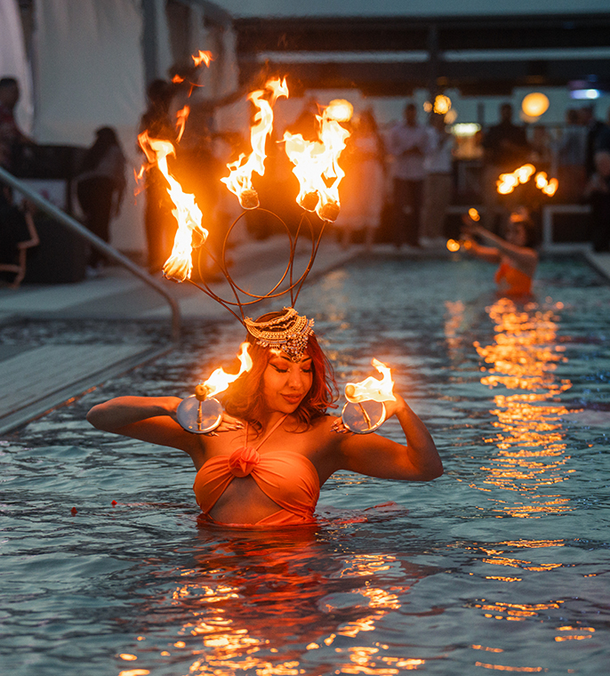 a woman in a pool with fire on her head
