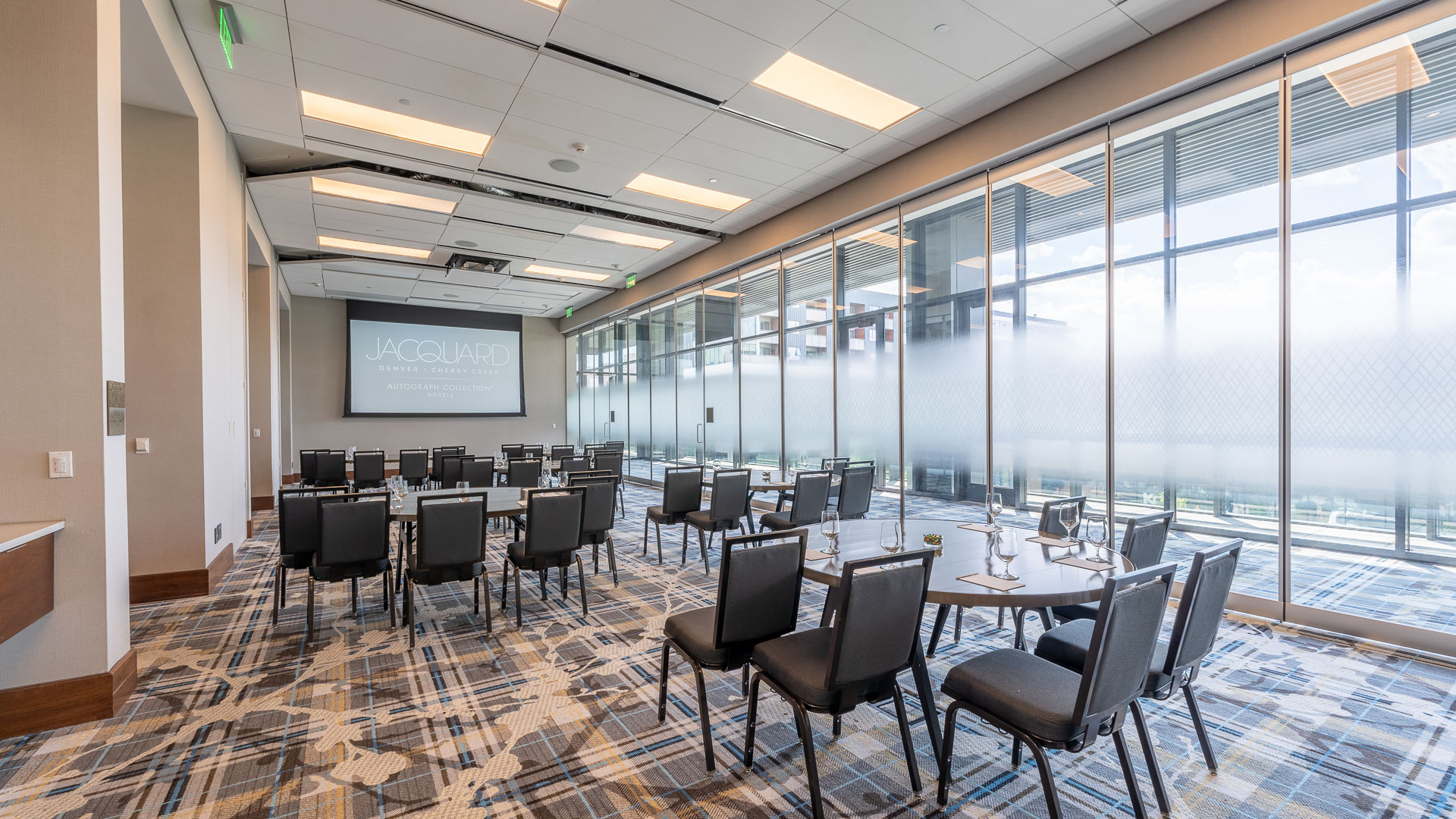 a room with a large screen and tables