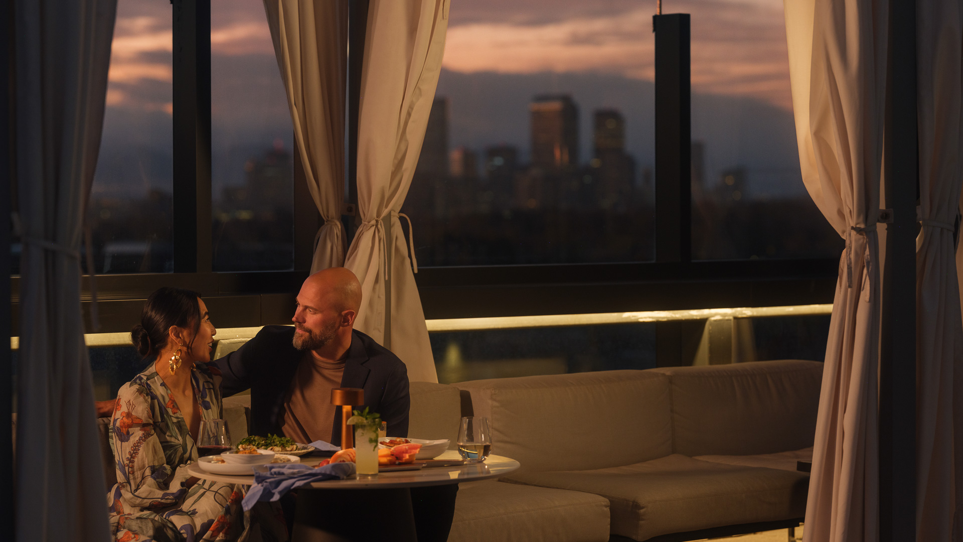 a man sitting at a table with food and drinks