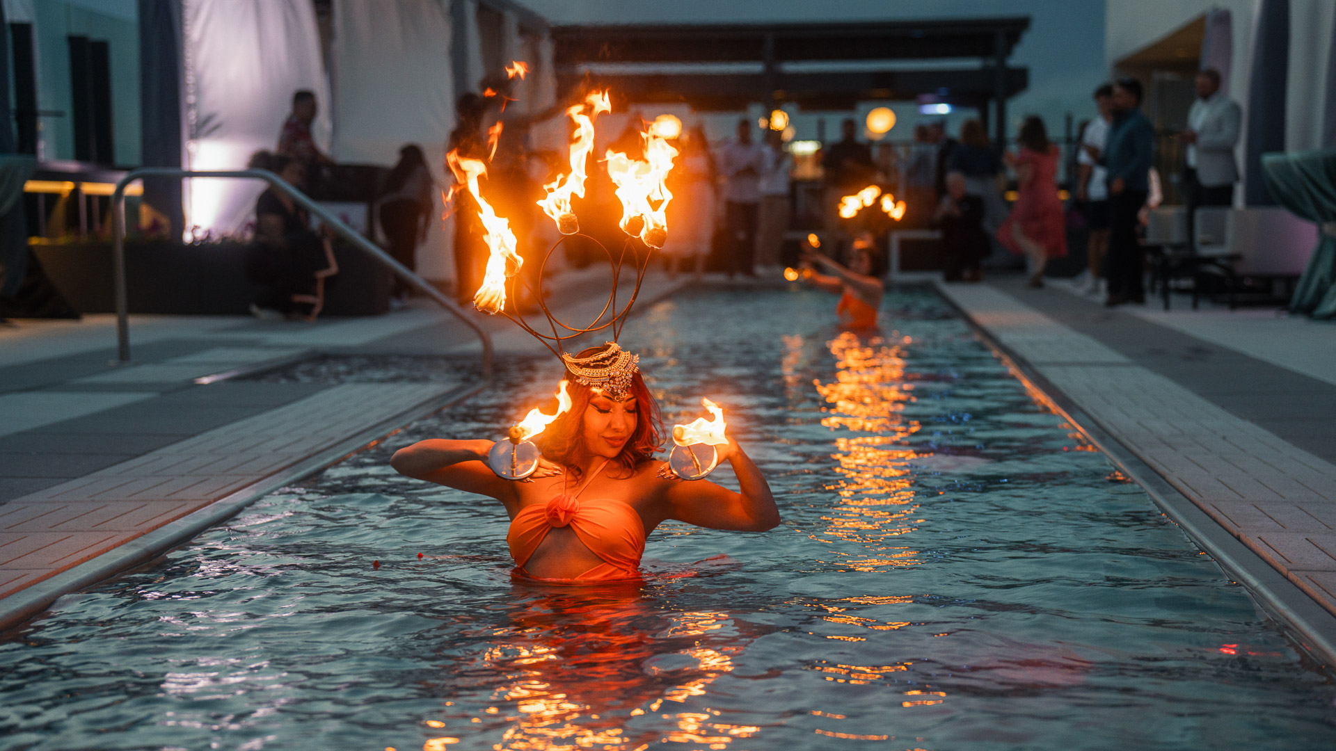 a woman in a pool with fire on her head