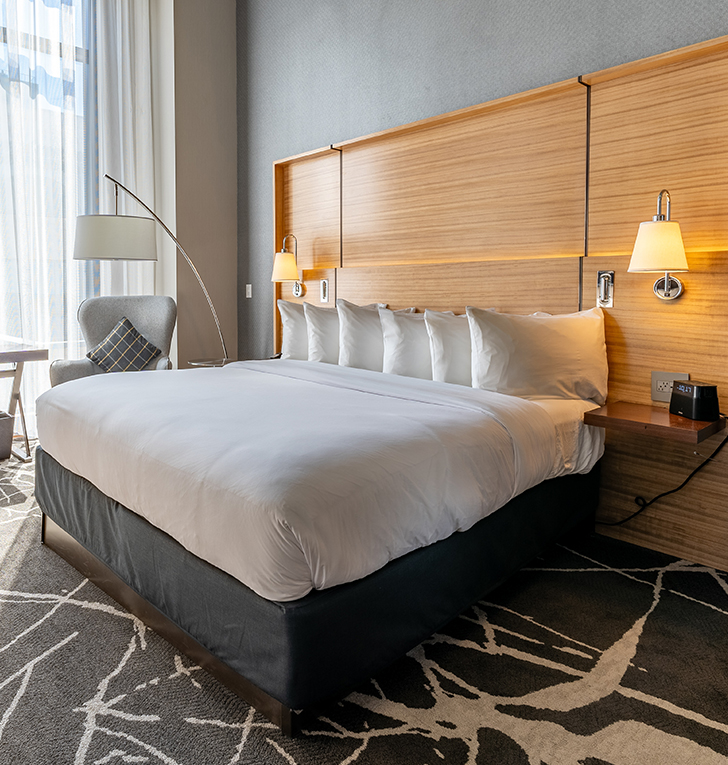 a bed with pillows and a lamp in a room