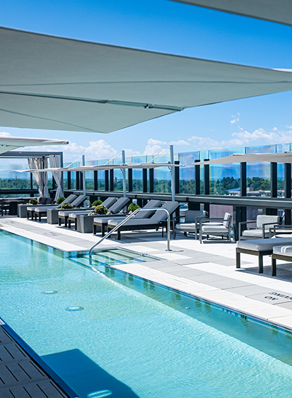 a pool with lounge chairs and a railing