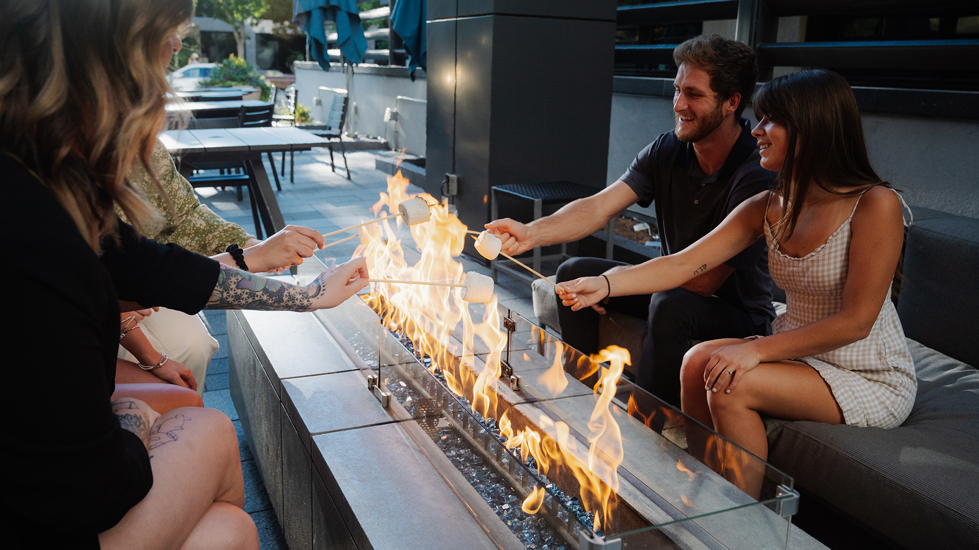 a group of people roasting marshmallows on a fire main