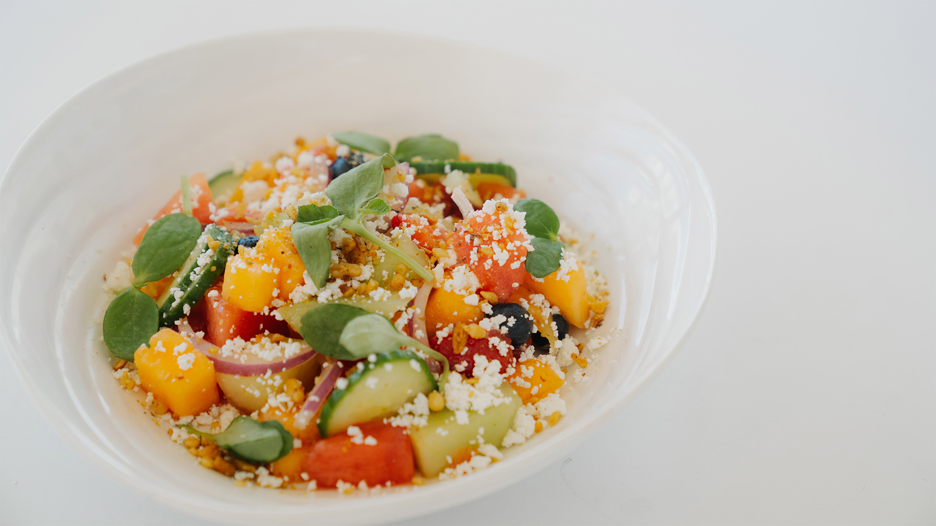 a bowl of salad with vegetables and cheese main