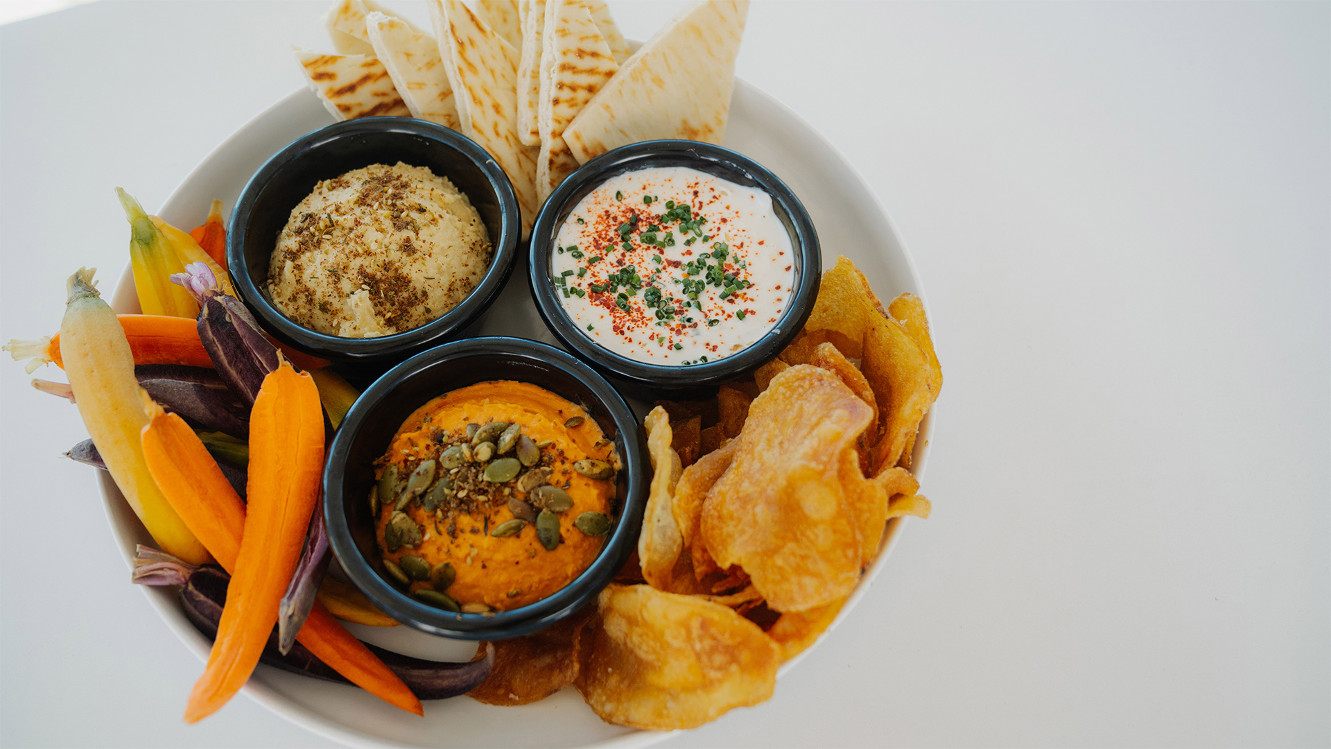 a plate of food with dips and chips main