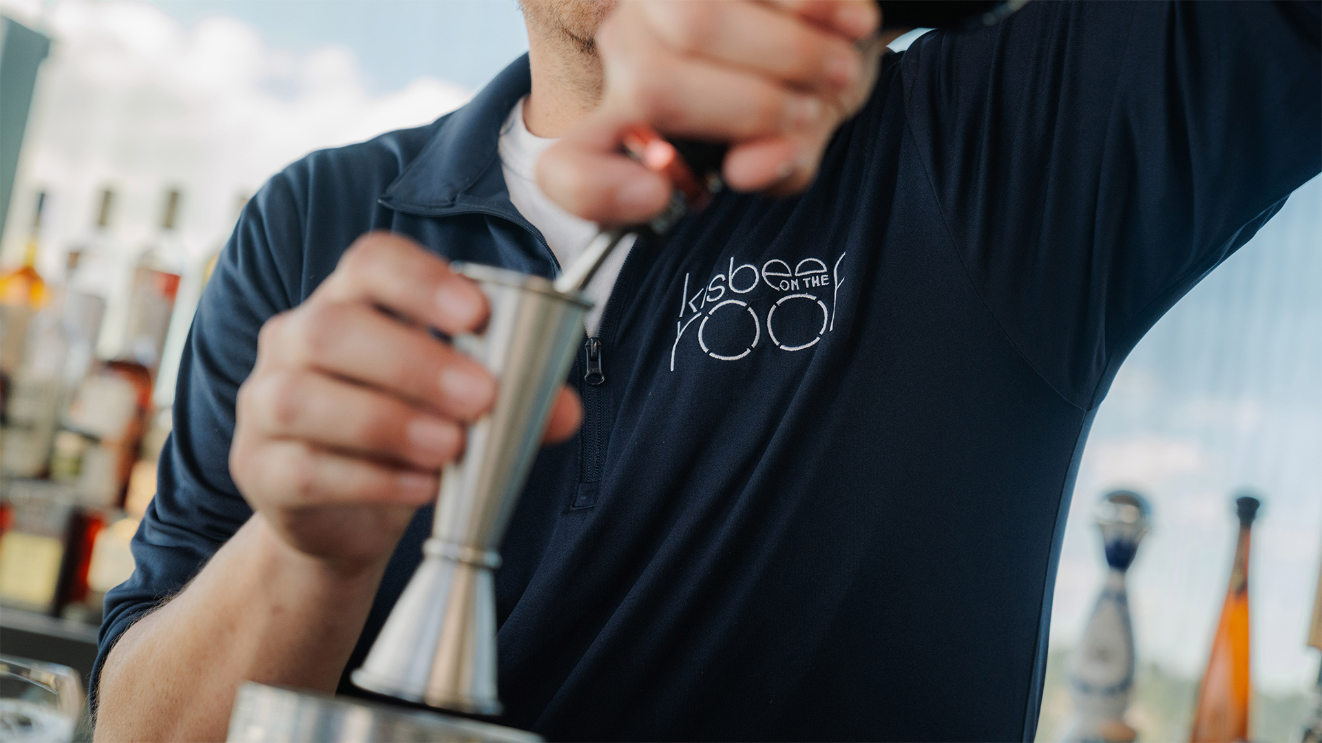 a man pouring a drink into a cup main