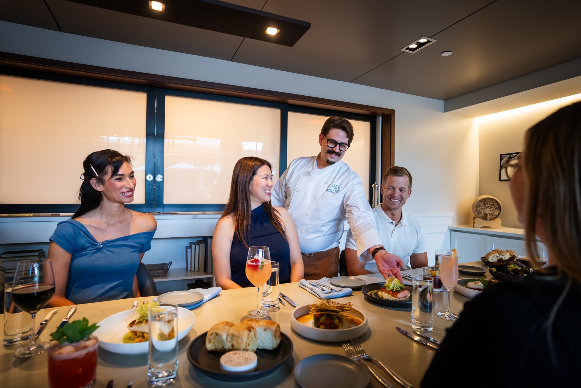 a group of people sitting at a table with food main