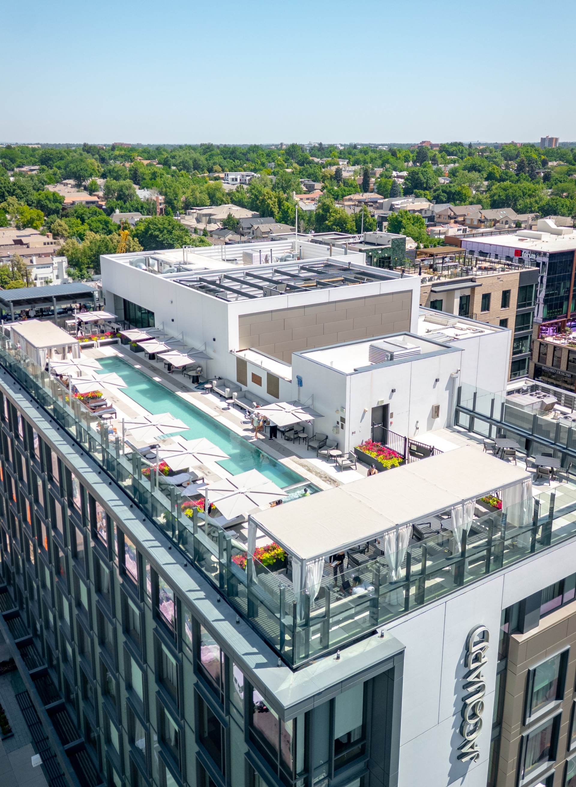 a rooftop pool with tables and chairs on top of the Jacquard Hotel