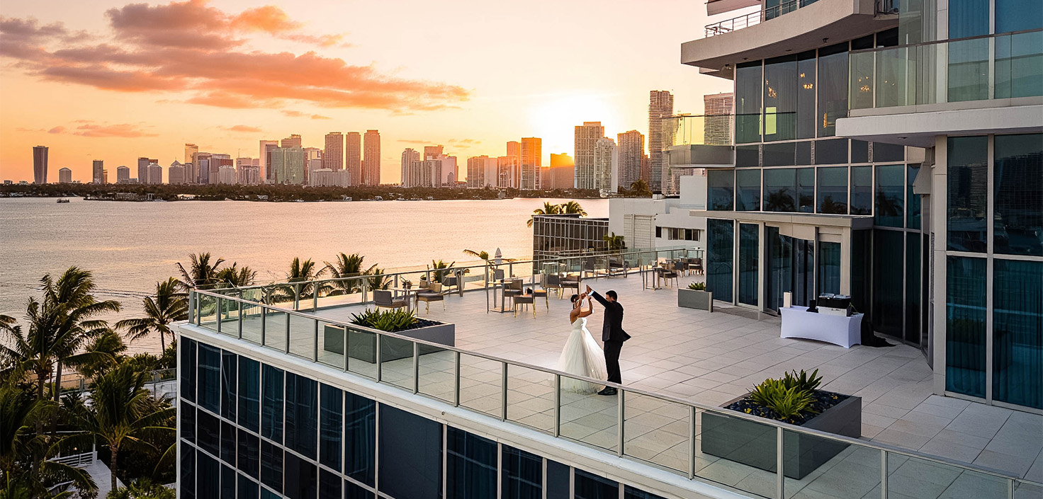 a man and woman standing on a rooftop overlooking a city