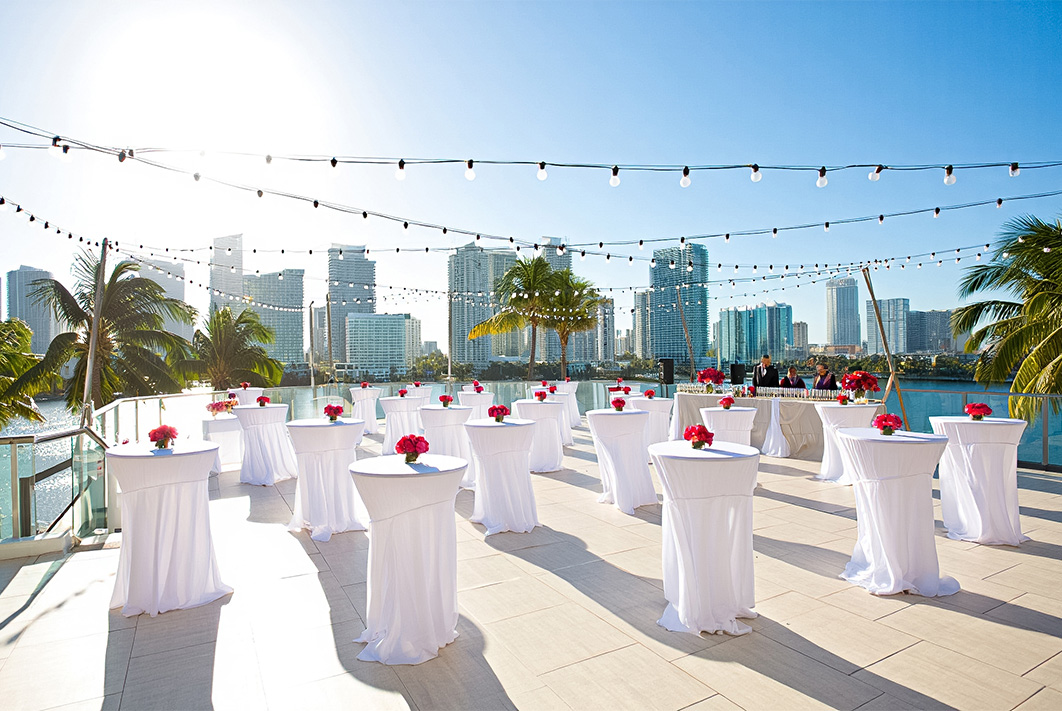 a group of tables with white tables and pink flowers on tables