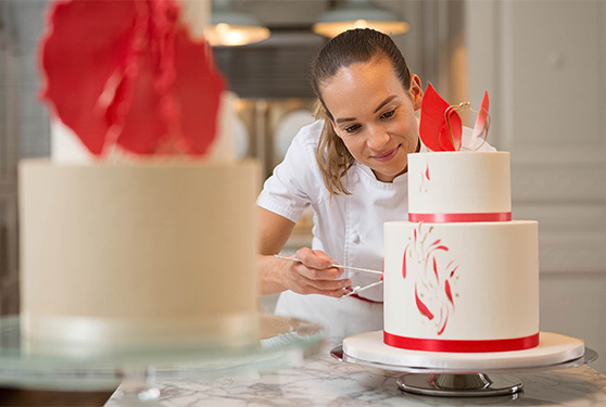 a woman decorating a cake