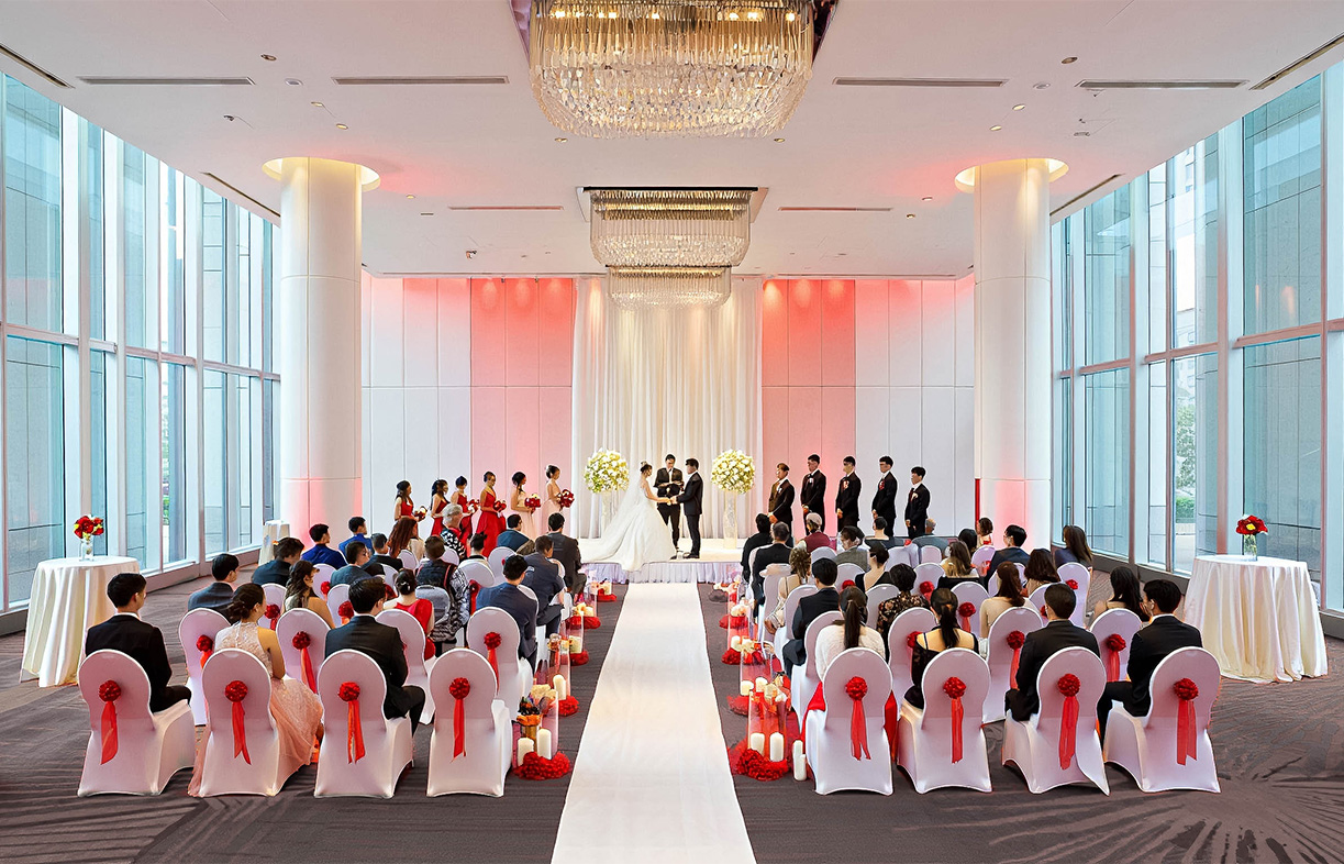 a group of people in a room with a wedding ceremony