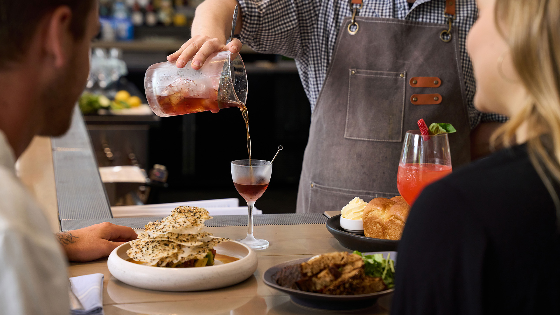 a person pouring a drink into a glass main