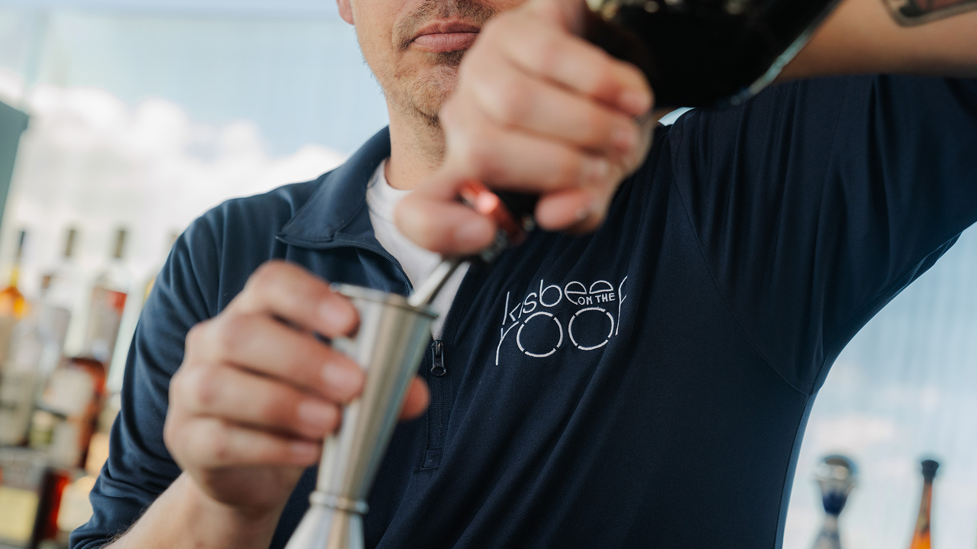 a man pouring a drink into a cup main