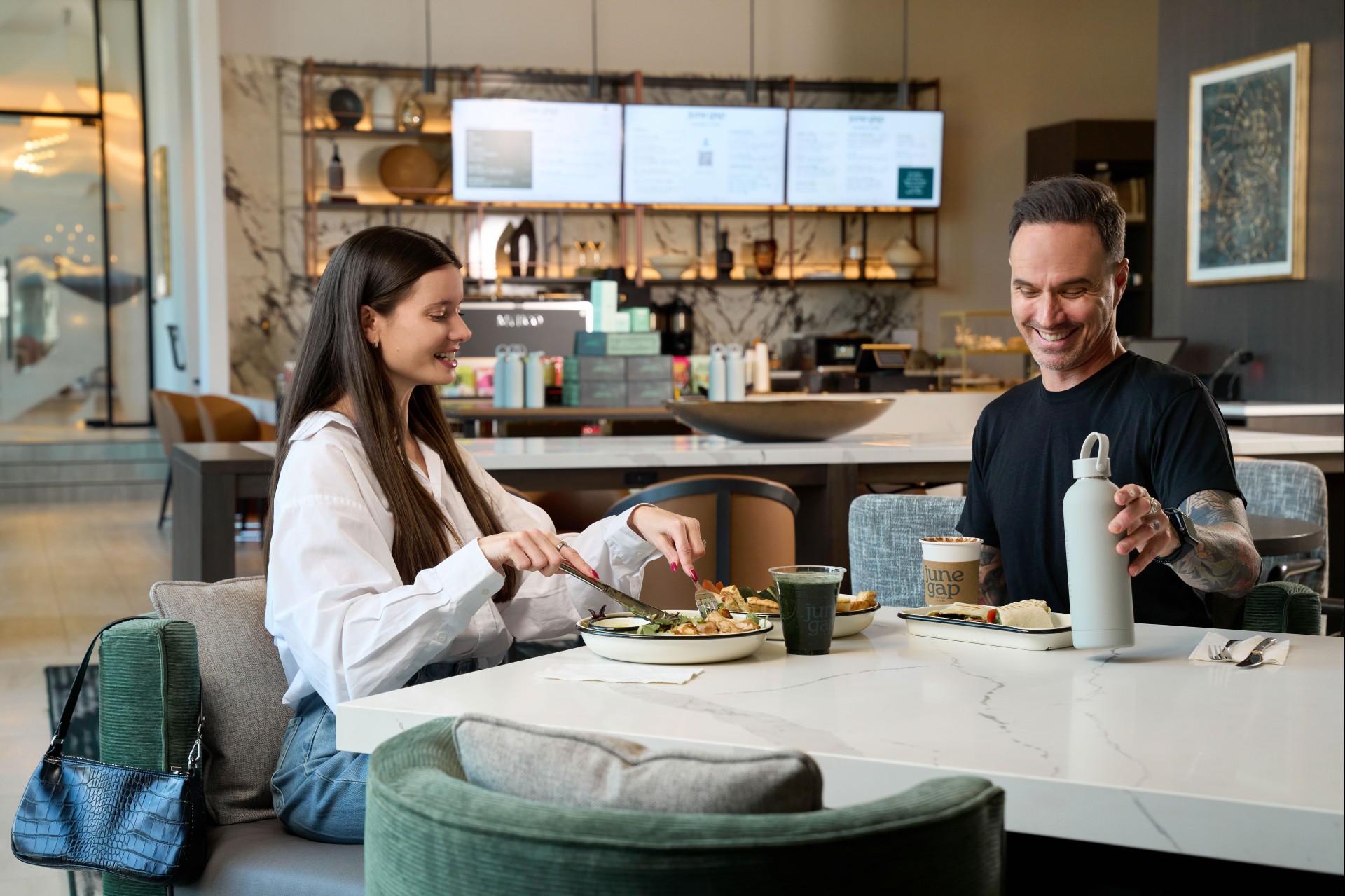 a man and woman sitting at a table eating food