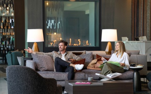 a man and woman sitting on a couch in the Apiary lobby