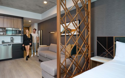 a man and woman walking in a guest room