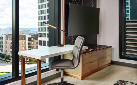 a desk next to a mounted tv