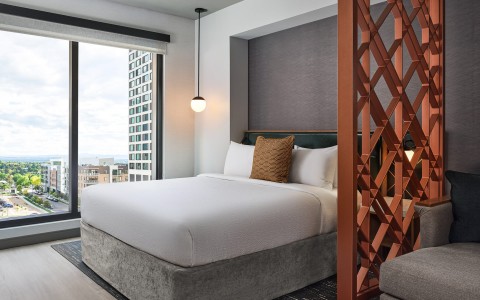 a bed with a white cover and a brown pillow