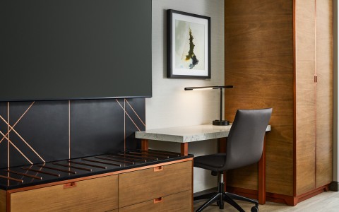 a desk with a lamp and a painting on the wall