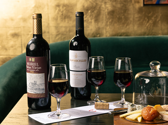 a table with wine glasses and cheese