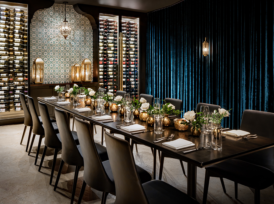 a long table with white flowers and black chairs