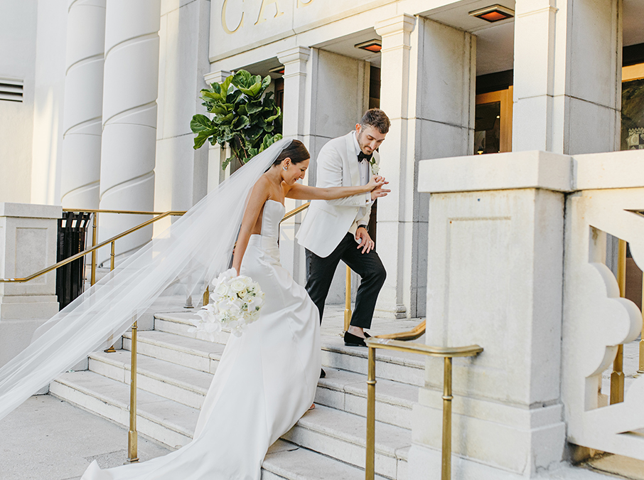 a bride and groom walking up stairs