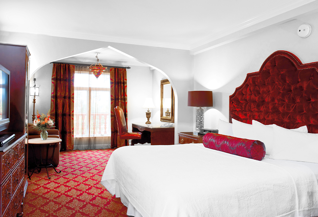 a bedroom with red carpet and a bed