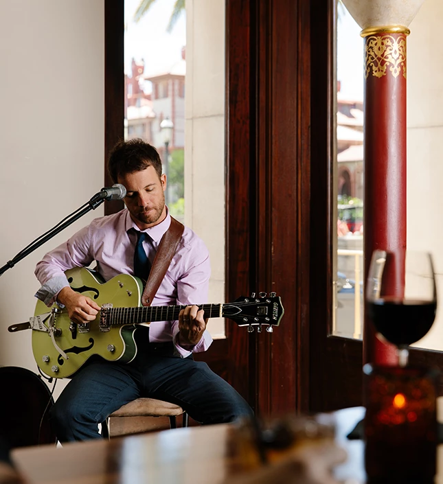 a man playing guitar and singing into a microphone