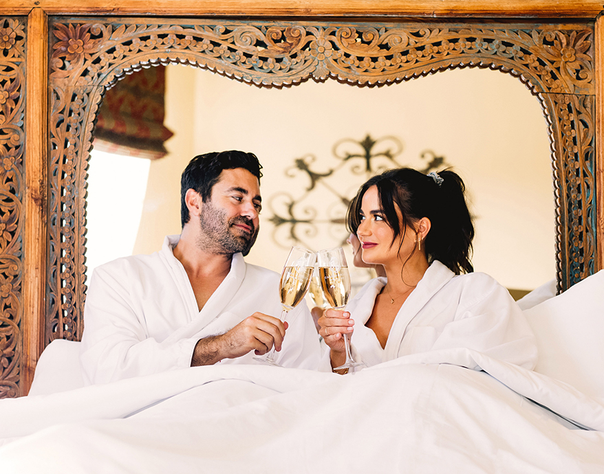 a man and woman in bathrobes holding champagne glasses