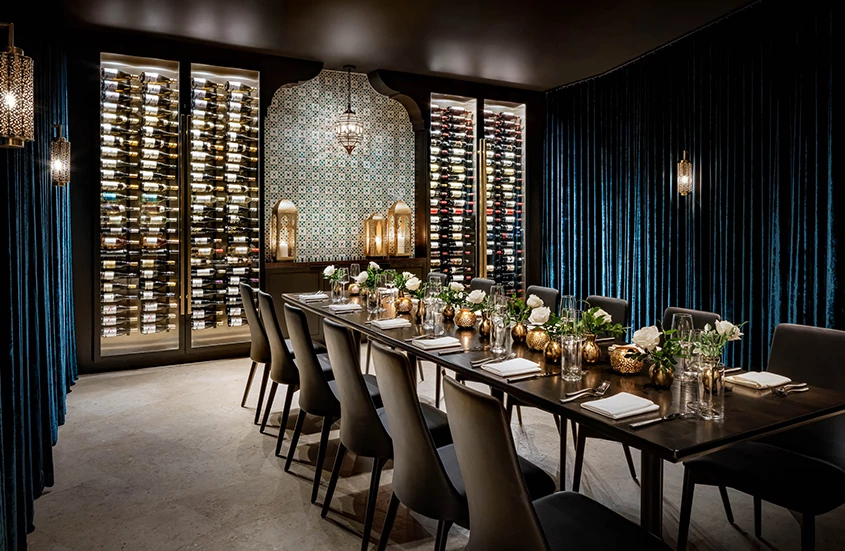 a long table with chairs and a wine rack