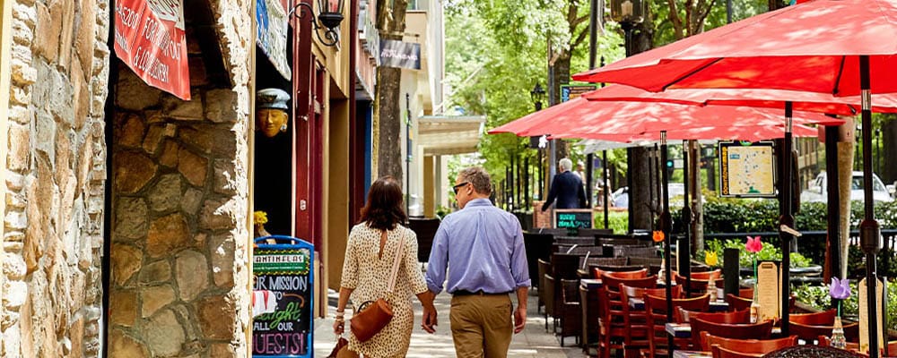 a man and woman walking down a sidewalk
