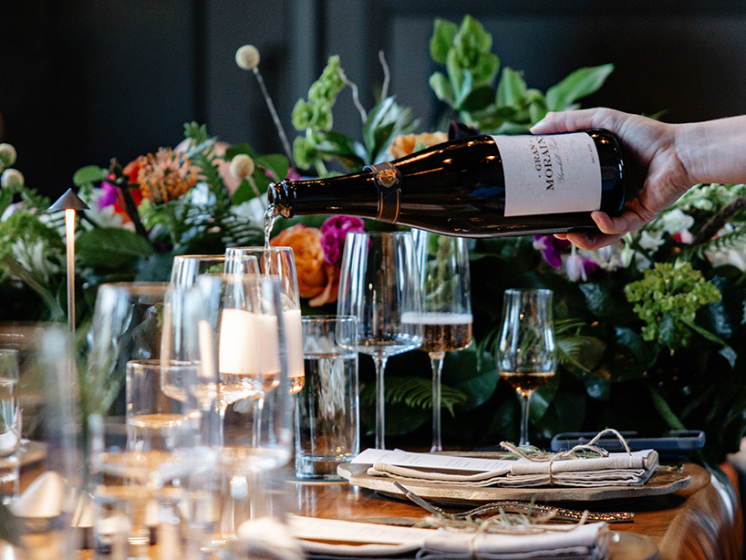 a person pouring wine into glasses