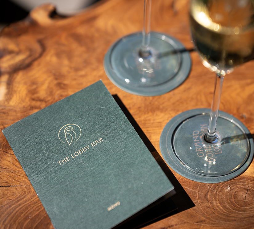 a menu and a glass of wine on a table