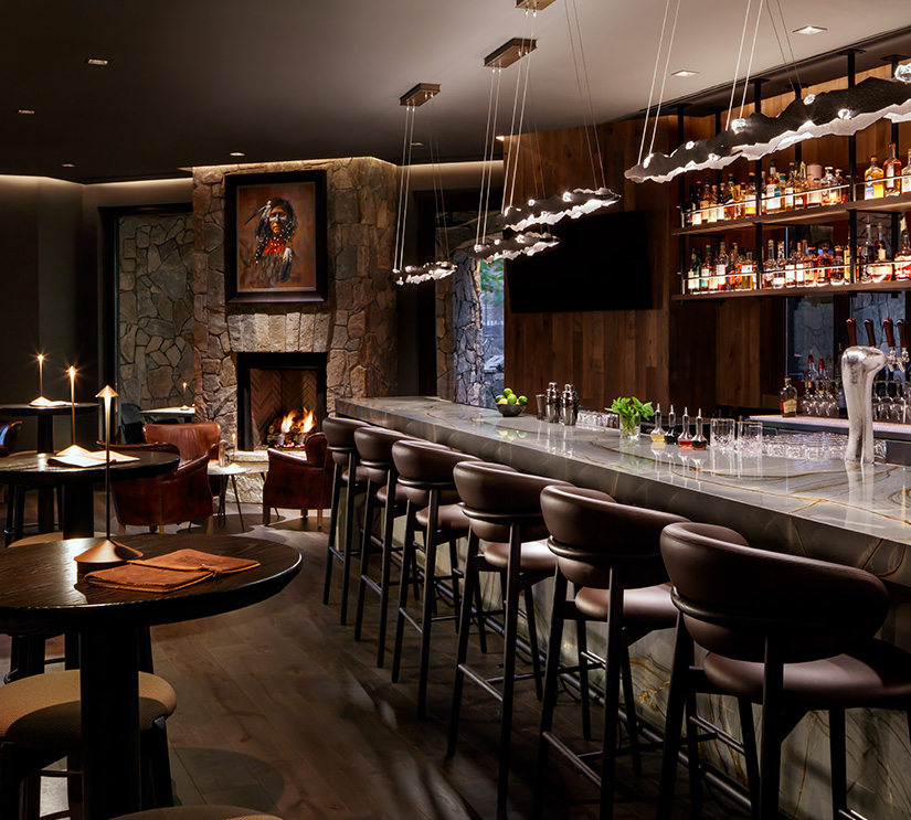 a bar with a fireplace and chairs