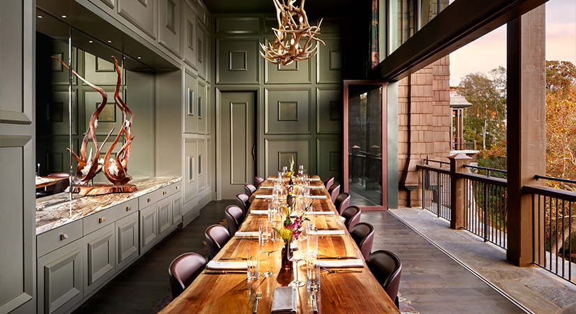 a long table with chairs and flowers