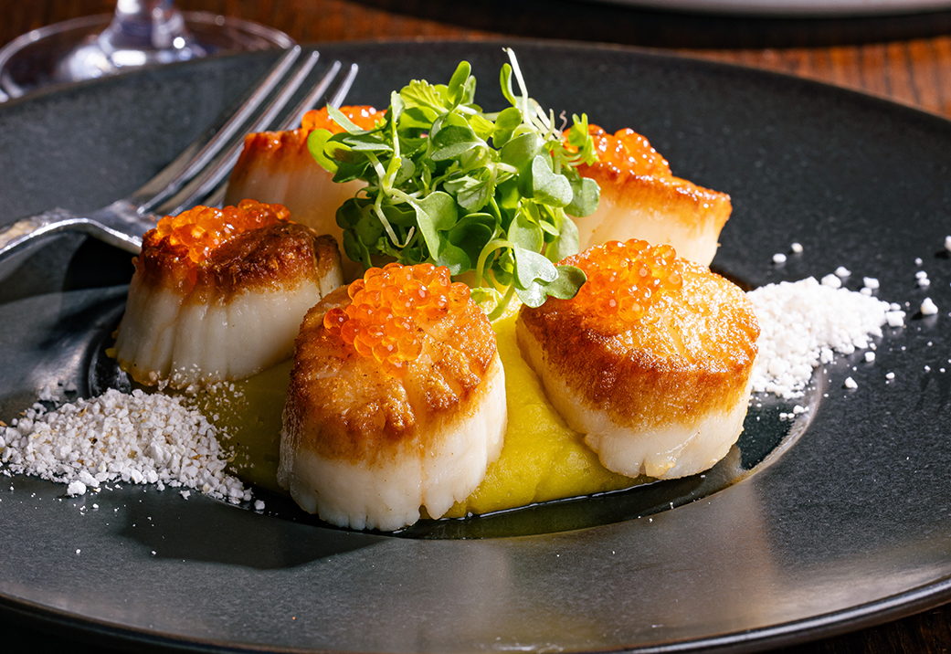 a plate of scallops and vegetables