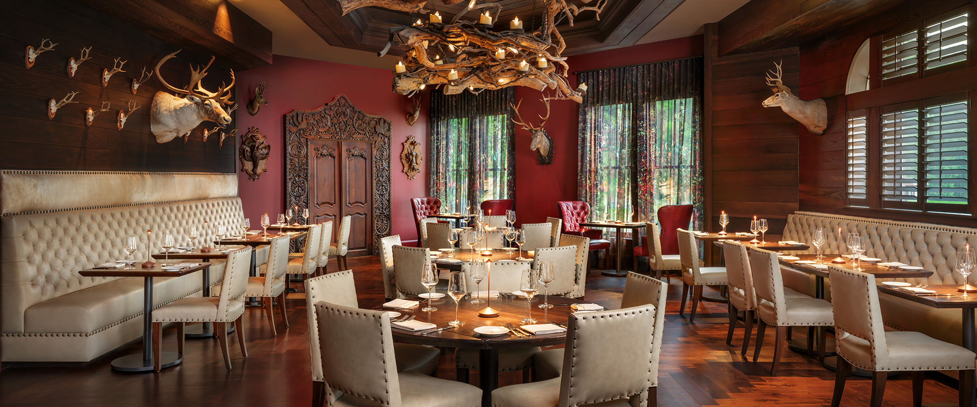 a room with a chandelier and tables and chairs