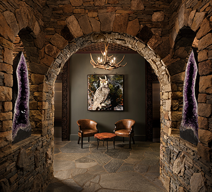 a stone archway with chairs and a picture on the wall